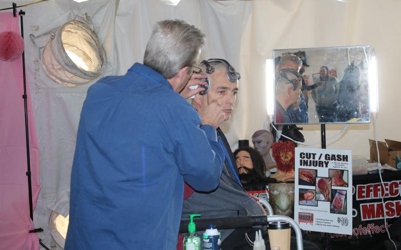 Professional special effects artist Jeh Howell turns an Infinity Con participant into a cyborg. Howell is a Live Oak resident known for his work in movies like “Cry for the Bad Men.” In the fitting chair, Fred Reed is also a animation and effects designer. (AMY HIETT/Special to the Reporter)