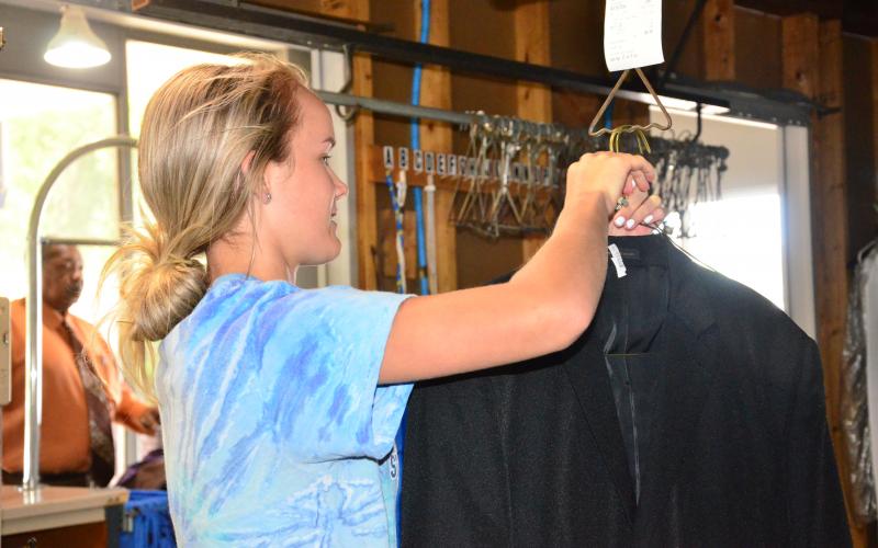 Gracie Rogers, an employee at Moses Cleaners on SW Main Boulevard, gets an item off the rack for a customer. (CARL MCKINNEY/Lake City Reporter)