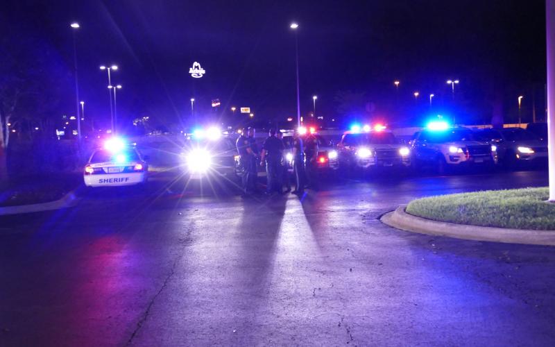 Some law enforcement officers join a park-and-pray vigil for Lake City Medical Center on Sunday night. The vigil was a show of support for the frontline hospital workers and patients. (TRAVIS LEE/Special to the Reporter)