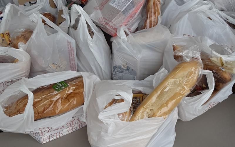 Bags containing bread and other food items await distribution at a local giveaway on Tuesday. The Worship Room, a new church founded in September, says it handed out roughly 40,000 pounds of food that day alone. (TOM NOTON/Special to the Reporter)