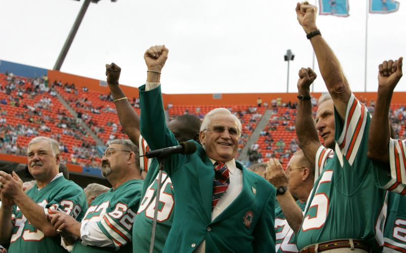Former Miami Dolphins head coach Don Shula, center, waves with former players from the 1972 unbeaten team during a ceremony at a football game against the Baltimore Ravens at Dolphin Stadium on Dec. 16, 2007, in Miami. From L-R: Running back Larry Csonka (39), center Jim Langer (62) and linebacker Nick Buoniconti, right. (LYNNE SLADKY/Associated Press)
