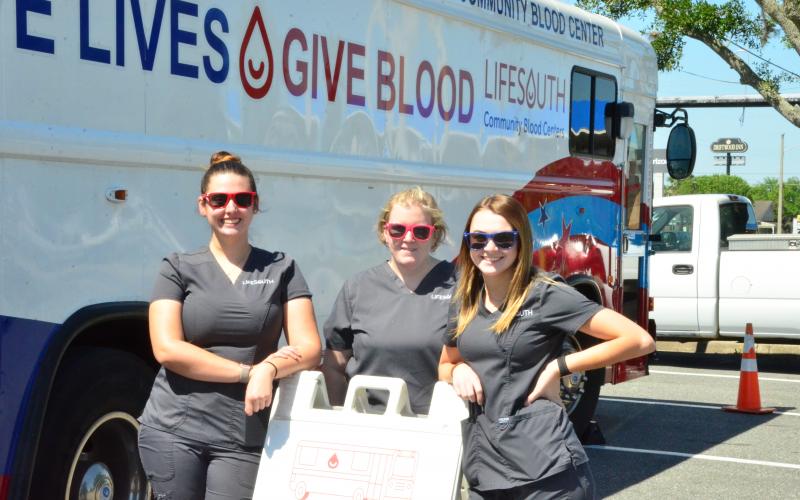 LifeSouth workers pose in front of the Bloodmobile on West U.S. 90 in this file photo from April. Pictured from left are donor services technician Savannah Thornton, team leader Brittany Shehan and donor services technician Bailee Mangrum. (CARL MCKINNEY/Lake City Reporter)