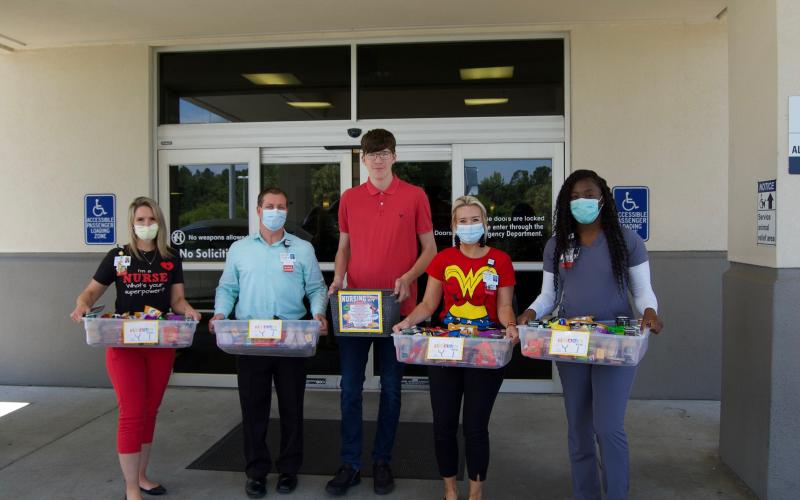 Lake City Medical Center employees accept snack baskets from Sandlin, pictured in the middle. On the far left is Alicia Swanson, to her left is Brian Sellers. To the right of Sandlin is Catherine Witt, and Jamecia Legree is to her left. (COURTESY)