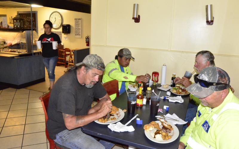 Workers with a local construction company enjoy their first dine-in meal in weeks late Monday morning at the Landing, a family buffet off U.S. 90. Pictured on the front left is Greg Walker, who is joined by Nicholas Flick at right, Aureliano San Juan in the back left and Danny Boone in the back right. (CARL MCKINNEY/Lake City Reporter)