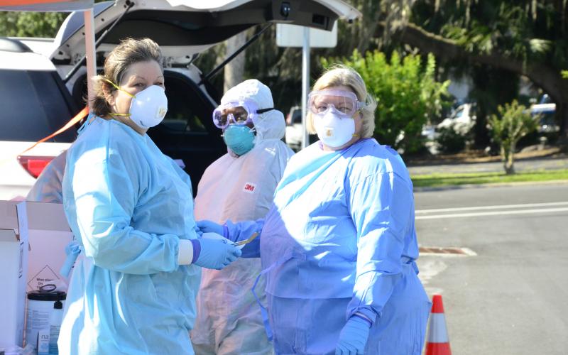 Workers from the Florida Department of Health suit up to begin testing.  (CARL MCKINNEY/Lake City Reporter)