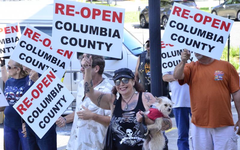 Anti-lockdown protesters march near the Columbia County Courthouse on Tuesday morning. The demonstrators called for all businesses to be allowed to reopen, even as the state has begun relaxing measures in place to curb the spread of covid-19. (CARL MCKINNEY/Lake City Reporter)