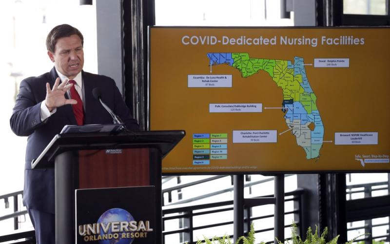 Florida Gov. Ron DeSantis speaks at a news conference at Universal Studios Wednesday, in Orlando. The Universal Studios theme park reopened today for season pass holders and will open to the general public on Friday. Bars and theme parks will be part of Florida's Phase 2 reopening after closure due to the coronavirus pandemic. (AP PHOTO))