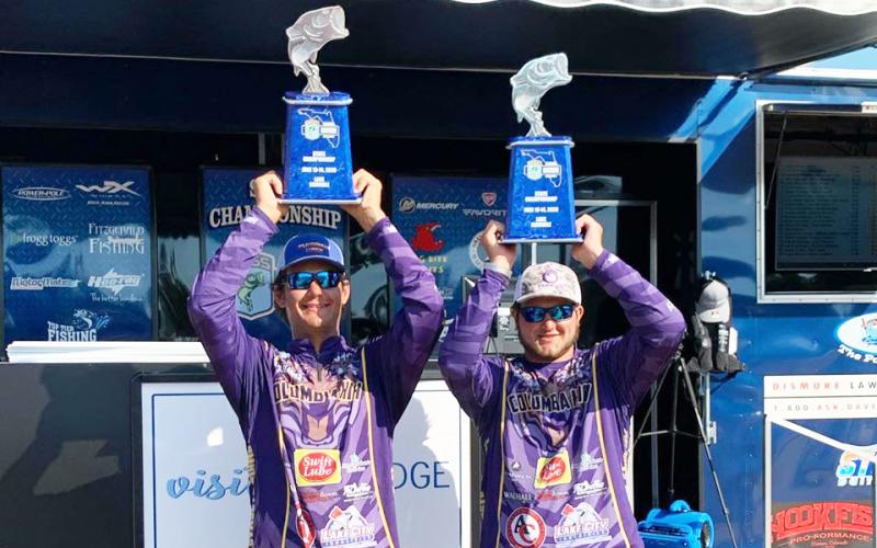 Columbia High Bassmasters Seth Slanker (left) and Jackson Swisher (right) raise their trophies after winning the Florida Bass Nation State Championship on Sunday. (COURTESY)