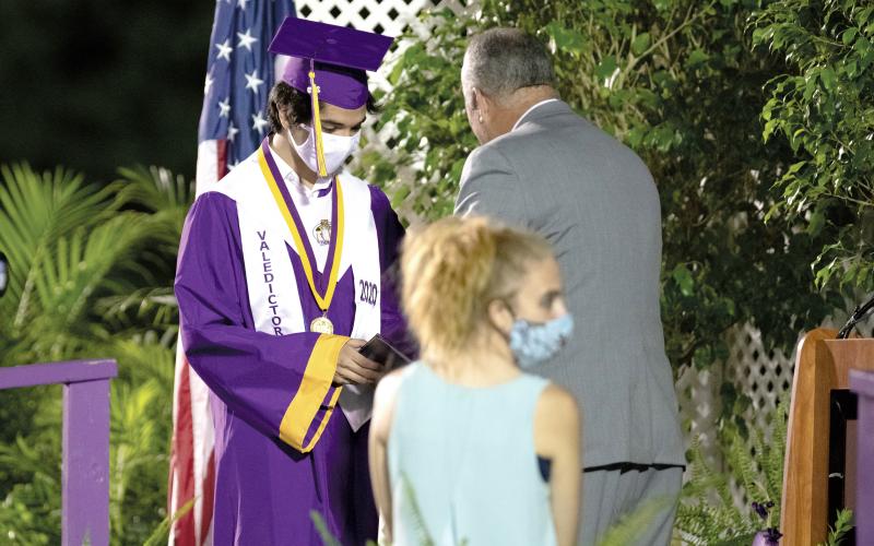 Columbia’s co-valedictorian Josiah Miller receives his diploma Saturday night at graduation. (RAY CARPENTER/Lake City Reporter)