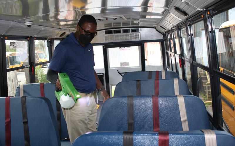William Highland, Columbia School District Transportation Department driver and safety trainer, uses a cordless electrostatic sprayer to disinfect a school bus on Thursday afternoon while preparing for the upcoming school year which begins on Monday. (TONY BRITT/Lake City Reporter)