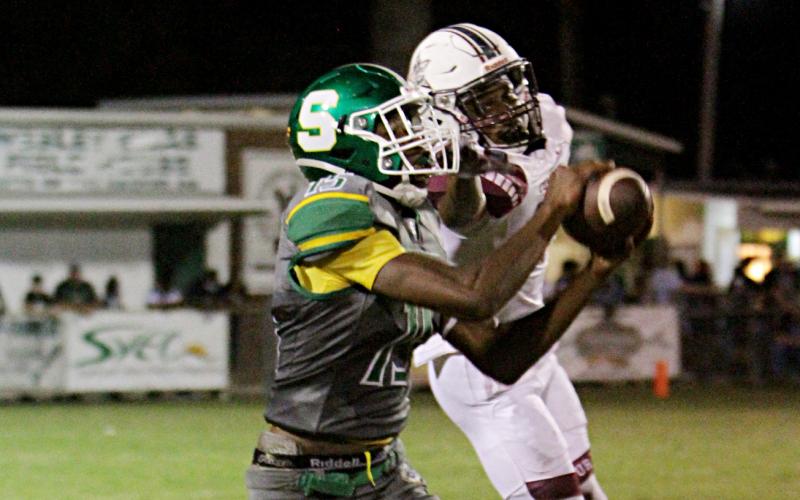 Suwannee receiver Brian Fuery catches a pass in front of a Madison County defender last Friday. (PAUL BUCHANAN/Special to the Reporter)