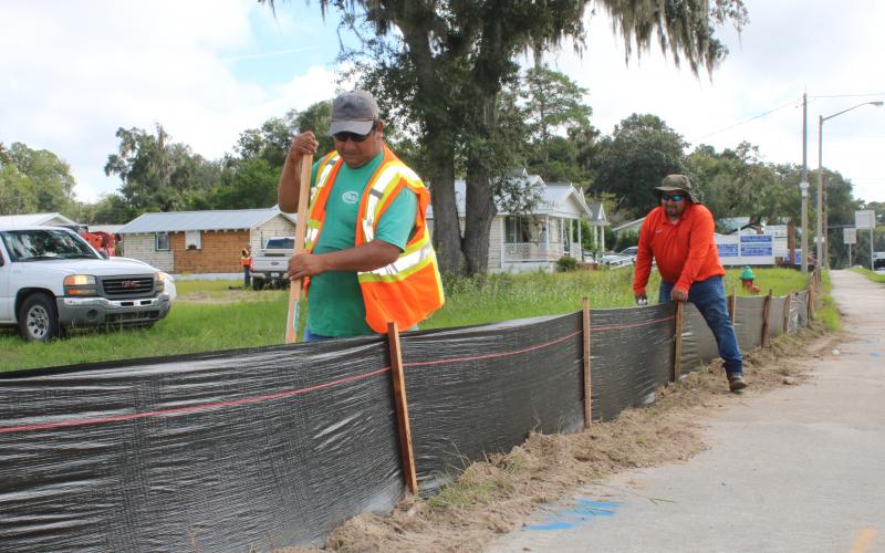 Construction workers erect erosion control black fencing around the Circle K store site at the intersection of U.S. Highway 90 and Baya Drive Wednesday morning. The store is expected to be completed within 22 weeks. (TONY BRITT/Lake City Reporter)