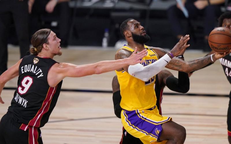 Los Angeles Lakers' LeBron James, right, drives to the basket past Miami Heat's Kelly Olynyk (9) during the second half of Game 1 of basketball's NBA Finals on Wednesday, in Lake Buena Vista. (MARK J. TERRILL/Associated Press)