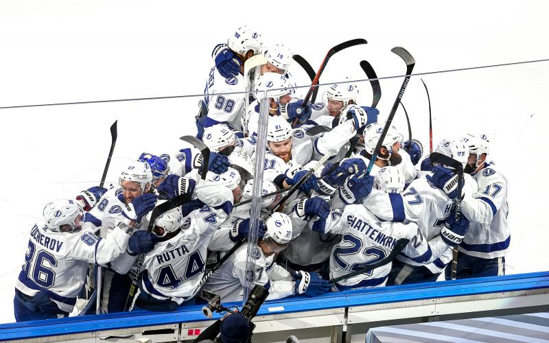 The Tampa Bay Lightning's Kevin Shattenkirk (22) is mobbed by his teammates after scoring the game-winning goal during the first overtime period for a 5-4 victory against the Dallas Stars in Game 4 of the Stanley Cup Finals on Friday, at Rogers Place in Edmonton, Canada. The Lightning lead the series, 3-1. (BRUCE BENNETT/Getty Images/TNS)