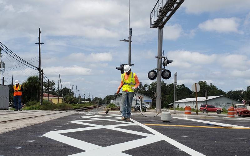 Crews finish work on the dynamic envelopes — giant connecting white X’s — at the rail crossing on U.S. Highway 129 (Ohio Avenue) in downtown Live Oak. The crossing reopened Monday night after being closed for two weeks for the improvements, which are part of the Florida Department of Transportation’s Operation STRIDE. (COURTESY FDOT)