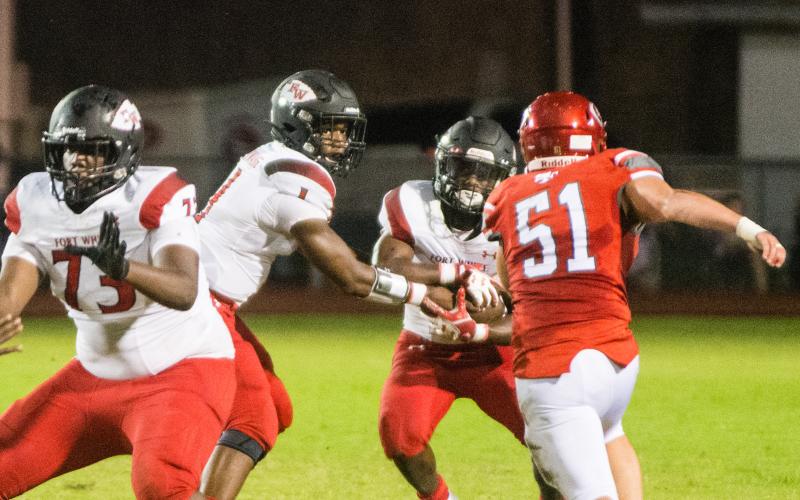 Fort White quarterback Tyler Jefferson hands the ball off to running back Tavion Taylor on Friday night. (CHRISTINA FEAGIN/Special to the Reporter)