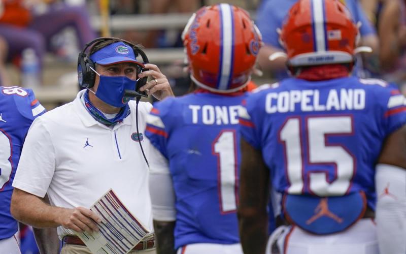 Florida head coach Dan Mullen, left, talks with wide receivers Kadarius Toney (1) and Jacob Copeland (15) during a timeout in a game against South Carolina on Oct. 3 in Gainesville. (JOHN RAOUX/AP Pool Photo)