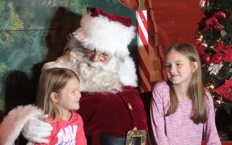 Santa Claus visits with Evelyn, left, and Darcy Floyd at last year’s Christmas on the Square in Live Oak. The Suwannee County Chamber of Commerce announced Tuesday the 36th annual festival will be held this year with safety protocols in place for the covid-19 pandemic. (SUWANNEE DEMOCRAT)