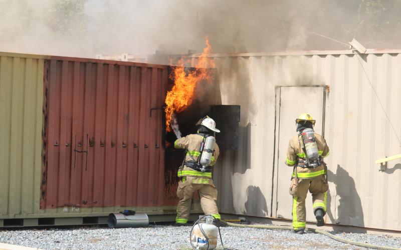 A firefighter uses a hose to douse flames coming from a window during a training session Friday. (TONY BRITT/Lake City Reporter)