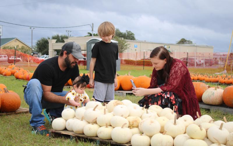 Brian Forte and his wife, Amanda, look through pumpkins at the Columbia FFA Pumpkin Patch with their children Kaiden (standing) and Railynn. (TONY BRITT/Lake City Reporter)