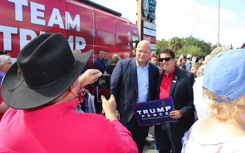 Earl Peeler takes a photo of former acting U.S. Attorney General Matt Whitaker and Columbia County Republican Chairman Hunter Peeler at Monday’s Team Trump Tour bus stop in Lake City.  (TODD WILSON/Lake City Reporter)