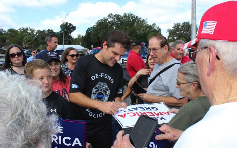 Matt Gaetz, a congressman from Florida’s First District in the Panhandle, signs autographs for President Donald Trump supporters after speaking at Monday’s rally in Lake City. (TODD WILSON/Lake City Reporter)