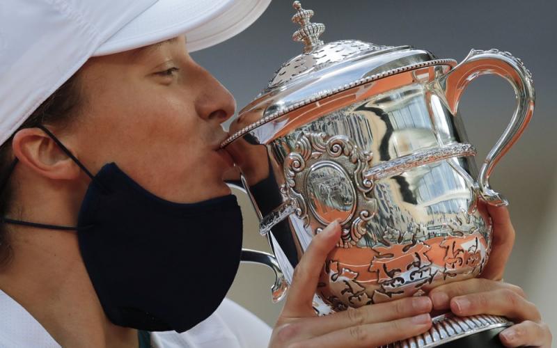 Iga Swiatek kisses the trophy after winning the final match of the French Open against Sofia Kenin in two sets 6-4, 6-1, at the Roland Garros stadium on Saturday in Paris, France. (CHRISTOPHE ENA/Associated Press)