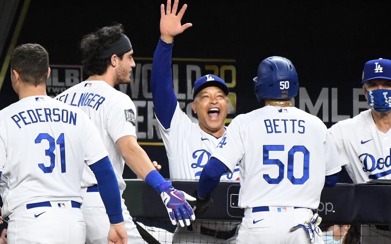 Los Angeles Dodgers manager Dave Roberts, middle, celebrates with Mookie Betts (50), who scored the go-ahead run against the Tampa Bay Rays in the sixth inning during Game 6 of the World Series at Globe Life Field on Tuesday in Arlington, Texas. (WALLY SKALIJ/Los Angeles Times/TNS)
