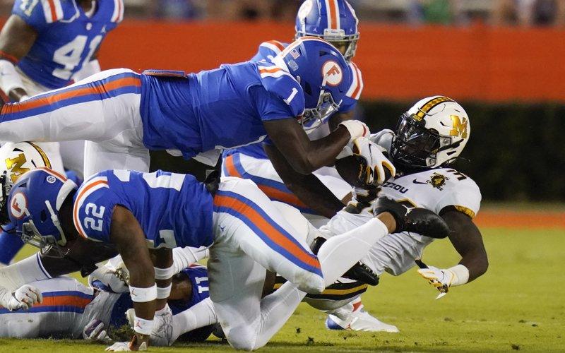 Missouri running back Larry Rountree III, right, is stopped by the Florida defense, including linebacker Brenton Cox Jr. (1) and defensive back Brad Stewart Jr., back, this past Saturday in Gainesville. (JOHN RAOUX/Associated Press)