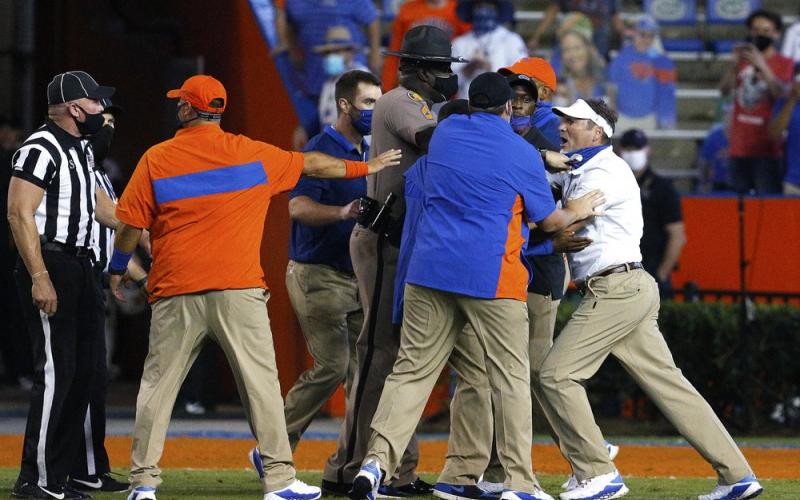 Florida coach Dan Mullen, right, is held back by coaches and law enforcement after a fight broke out at the end of the first half of Saturday's game against Missouri in Gainesville. (BRAD MCLENNY/The Gainesville Sun via AP)