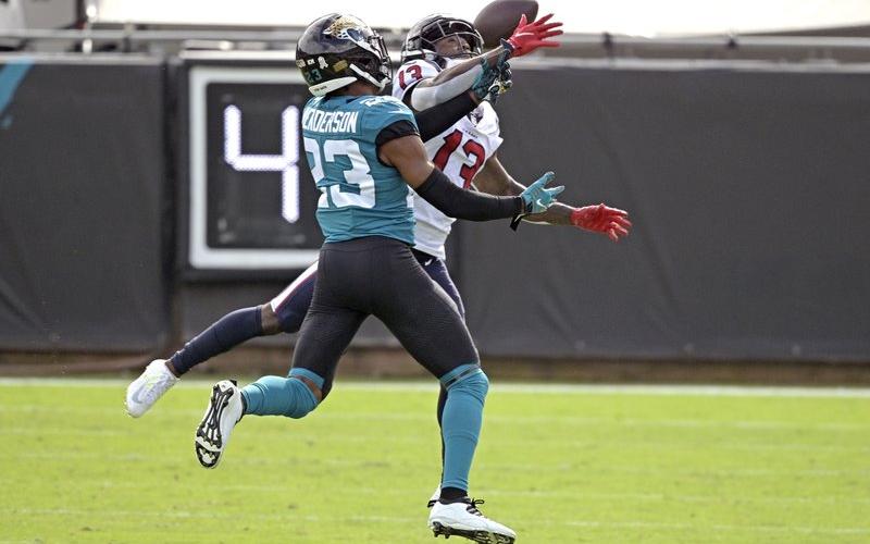 Jacksonville Jaguars cornerback CJ Henderson, left, breaks up a pass intended for Houston Texans wide receiver Brandin Cooks (13) last Sunday in Jacksonville. (PHELAN M. EBENHACK/Associated Press)