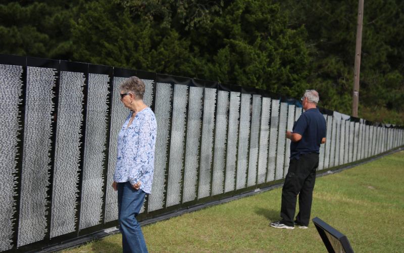 Nancy Chauncey and her husband Stanley Chauncey, of Lake City, look at names on the Vietnam Traveling Memorial Wall Thursday afternoon. The wall will be on display next door to the Honda of Lake City through Tuesday. (TONY BRITT/Lake City Reporter)