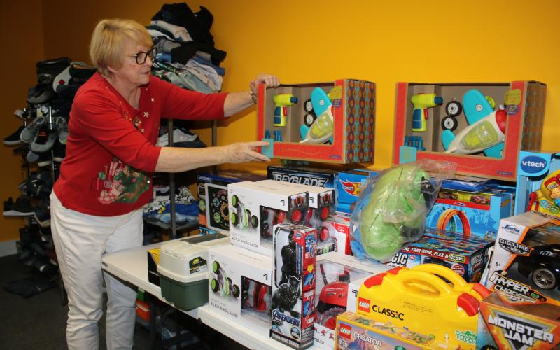 Meally Jenkins, Christmas Dream Machine founder and director, arranges toys in the agency’s office Friday afternoon. The Christmas Dream Machine opened Sunday and has already compiled a list of 100 children to serve this holiday season. (TONY BRITT/Lake City Reporter)