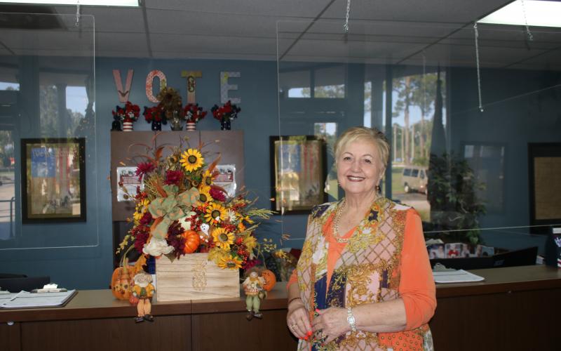 Liz P. Horne, the Columbia County supervisor of elections, stands at the elections office desk. Horne, who has worked at the office for more than 20 years, will retire on Dec. 31. (TONY BRITT/Lake City Reporter)