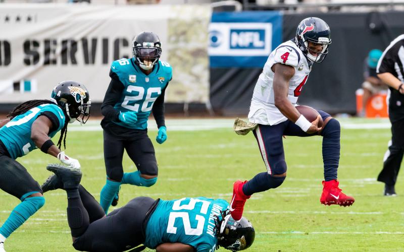 Houston Texans quarterback Deshaun Watson (4) leaps over Jacksonville Jaguars defensive tackle DaVon Hamilton (52) in the fourth quarter of Sunday's game in Jacksonville. (TRIBUNE NEWS SERVICE)