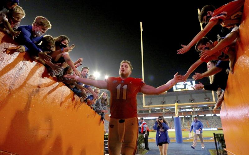 Florida quarterback Kyle Trask (11) is congratulated by fans as he leaves the field after the team's win over Arkansas on Saturday in Gainesville. (BRAD MCCLENNY/via AP)