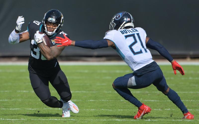 Jacksonville Jaguars running back James Robinson (30) eludes Tennessee Titans cornerback Malcolm Butler (21) during first quarter action at TIAA Bank Field on Sunday in Jacksonville. BOB SELF/TNS)