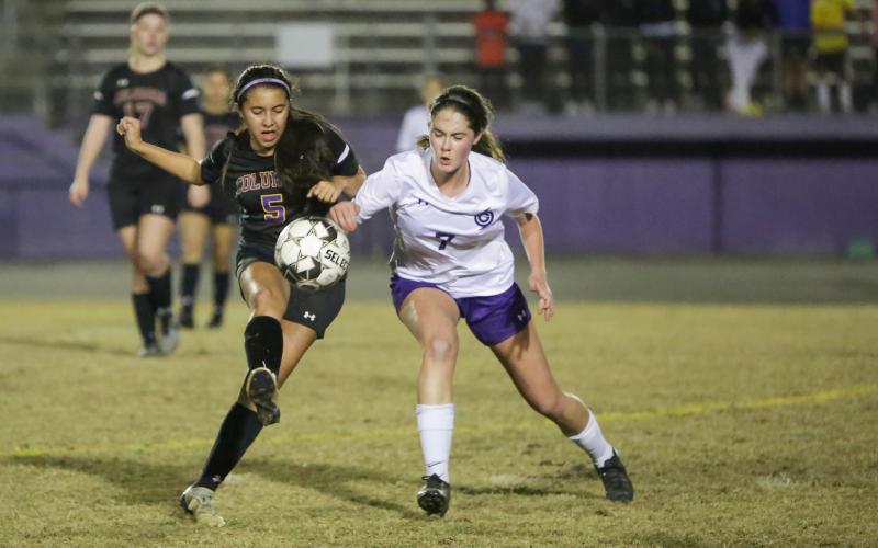Columbia’s Carla Medina fights for possession of the ball with Gainesville’s Zoe Lammers on Thursday night. (BRENT KUYKENDALL/Lake City Reporter)