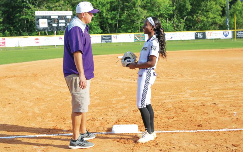 Columbia pitcher Cris’Deona Beasley laughs with assistant coach Mitch Shoup prior to the team’s game against Baker County on Apr. 12. (BRENT KUYKENDALL/Lake City Reporter)