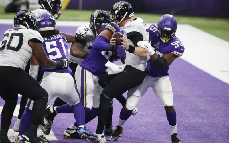 Jacksonville Jaguars quarterback Mike Glennon (center) is tackled for a safety by Minnesota Vikings defensive end Ifeadi Odenigbo, right, on Sunday in Minneapolis. (BRUCE KLUCKHOHN/Associated Press)