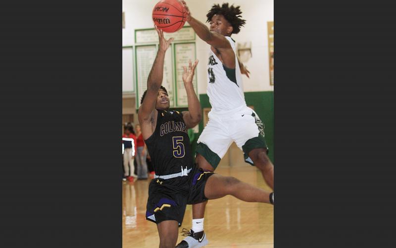 Suwannee forward Anthony Brown blocks Columbia guard Daniel Anderson’s shot during Saturday’s game. The Bulldogs defeated the Tigers 65-58. (PAUL BUCHANAN/Special to the Reporter)