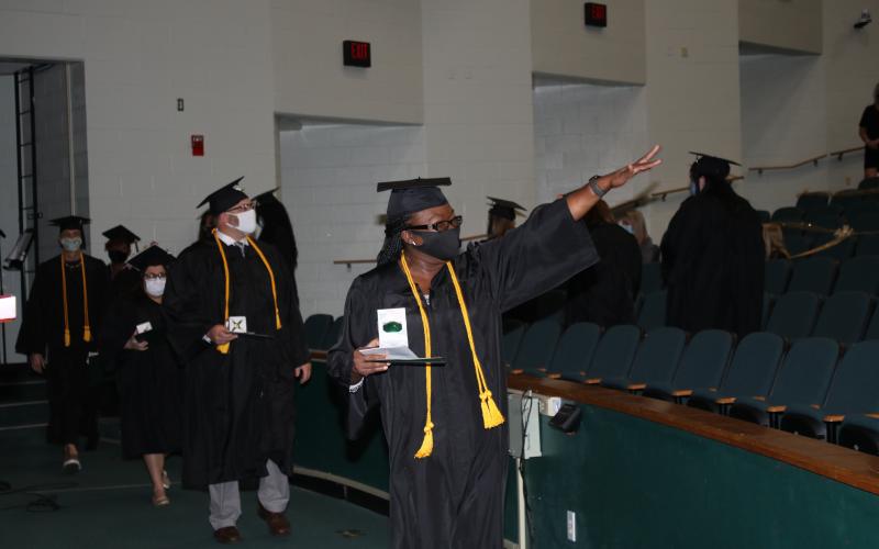 Deandrea Lee waves to family members after she received her bachelors degree in early childhood education during commencement exercises Thursday evening at Florida Gateway College. (TONY BRITT/Lake City Reporter)