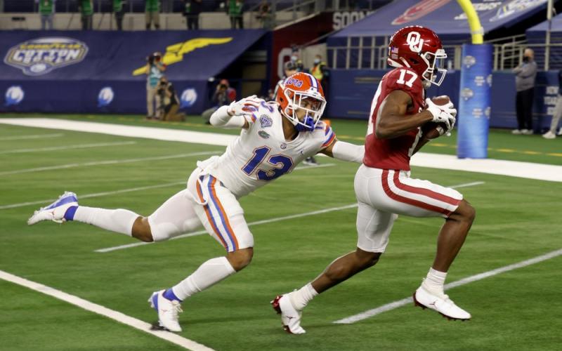 Florida defensive back Donovan Stiner (13) is unable to stop Oklahoma wide receiver Marvin Mims (17) from reaching the end zone on a touchdown reception during the first half of the Cotton Bowl on Wednesday in Arlington, Texas. (MICHAEL AINSWORTH/Associated Press)