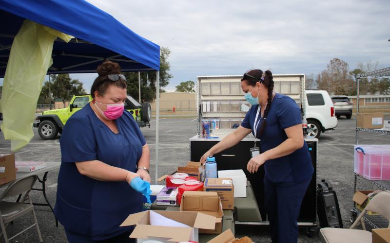 Sarah White (left) and Sara Driggers, Columbia County Health Department nurses, pack up vaccination supplies after helping to vaccinate 630 residents with the covid-19 vaccine on Thursday. The workers vaccinated 630 people in six hours. (TONY BRITT/Lake City Reporter)