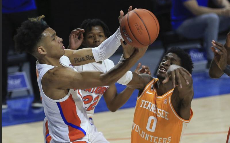 Florida guard Tre Mann (1) and Tennessee guard Davonte Gaines (0) compete for a rebound on Tuesday in Gainesville. (MATT STAMEY/Associated Press)