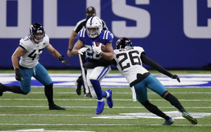 Indianapolis Colts' Jonathan Taylor (28) runs past Jacksonville Jaguars' Jarrod Wilson (26) on Sunday in Indianapolis. (AJ MAST/Associated Press)