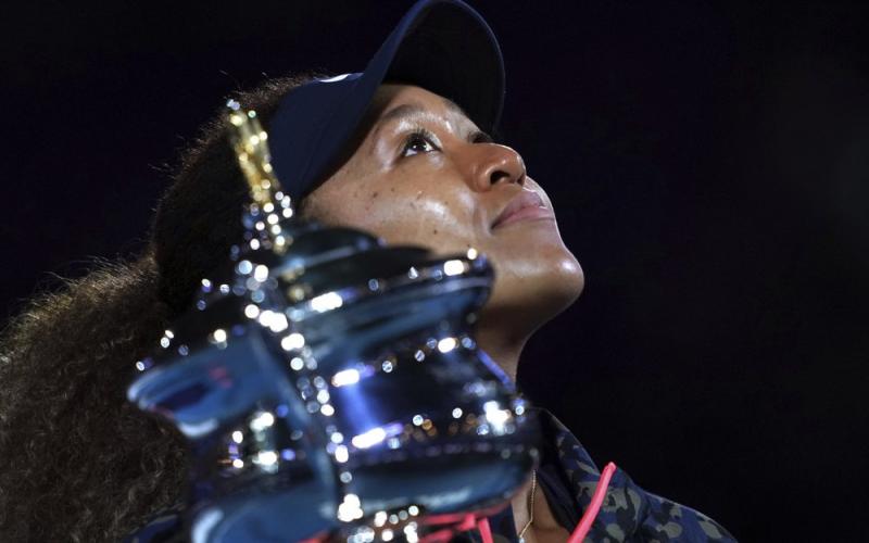 Naomi Osaka holds the Daphne Akhurst Memorial Cup aloft defeating Jennifer Brady in the women's singles final at the Australian Open on Saturday  in Melbourne, Australia. (MARK DADSWELL/Associated Press)