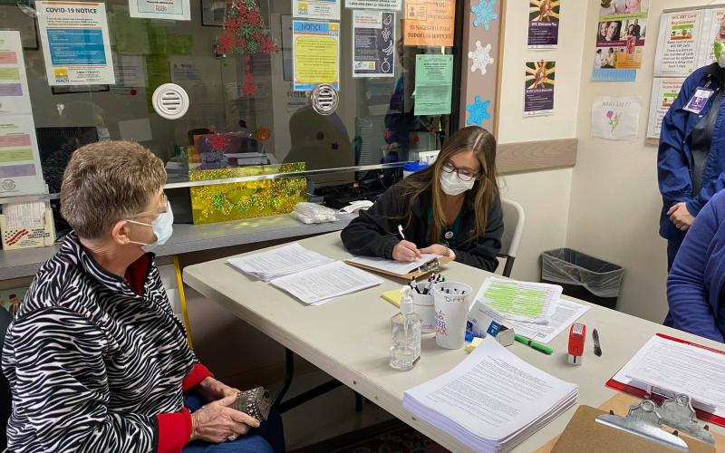 A practical nursing student from Riveroak Technical College assists checking in a patient for their covid-19 vaccine. Students from the college are helping the health departments in Suwannee and Lafayette counties with their vaccine events. (COURTESY)