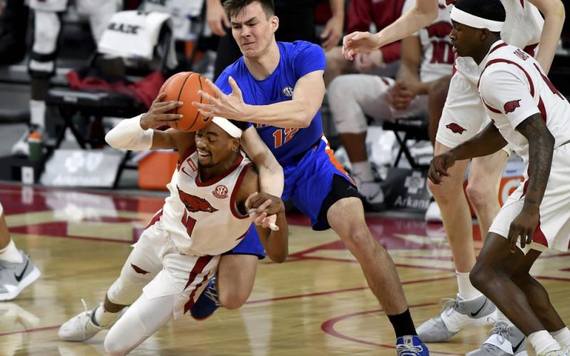 Arkansas guard Jalen Tate (11) and Florida forward Colin Castleton (12) fight for a rebound during Tuesday's game in Fayetteville, Ark.. (MICHAEL WOODS/Associated Press)