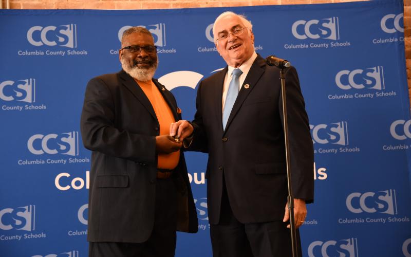 Carlos Brown, the Columbia County Schools’ 2020 School-Related Employee of the Year (left), receives a key to the city from Lake City Mayor Stephen Witt at Thursday’s banquet. (COURTESY)